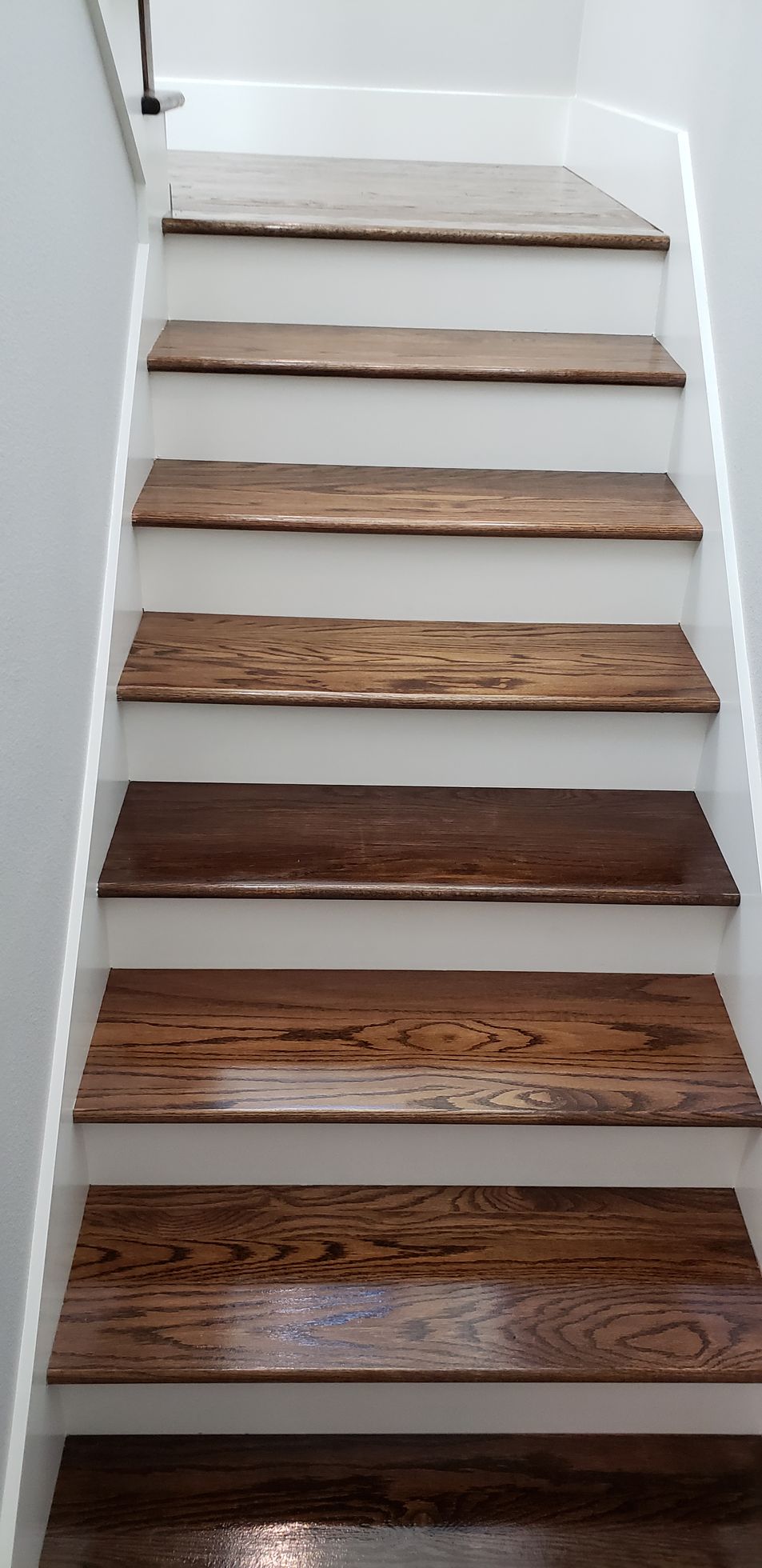 A set of stairs with wooden steps and white railings.