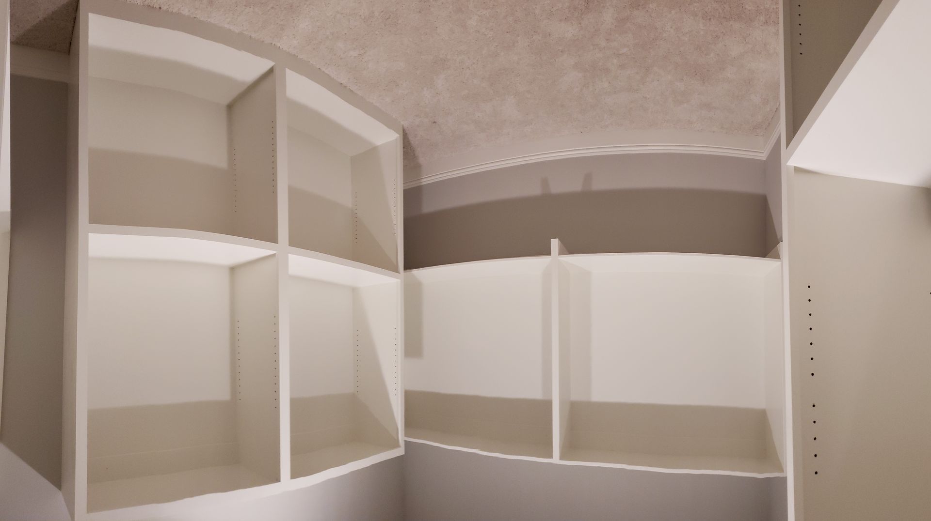 A closet with a lot of shelves and a ceiling.