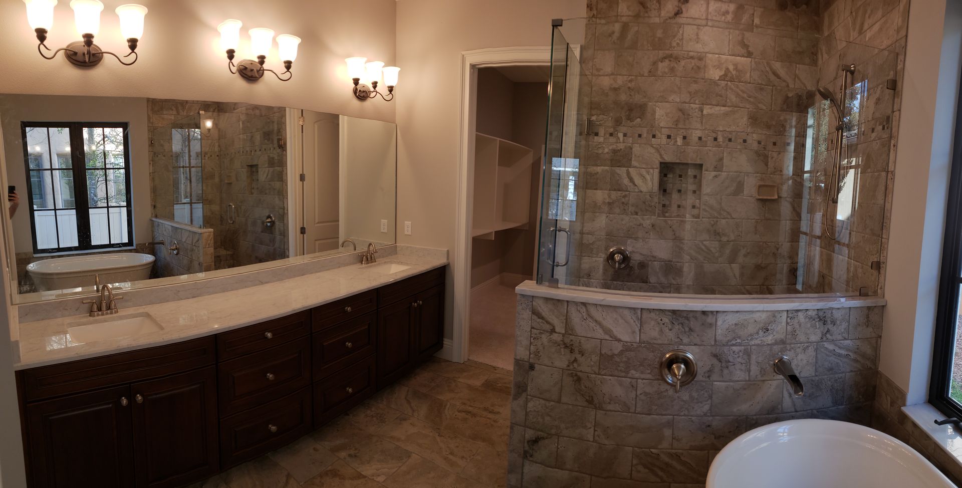 A bathroom with two sinks , a tub , a shower and a large mirror.