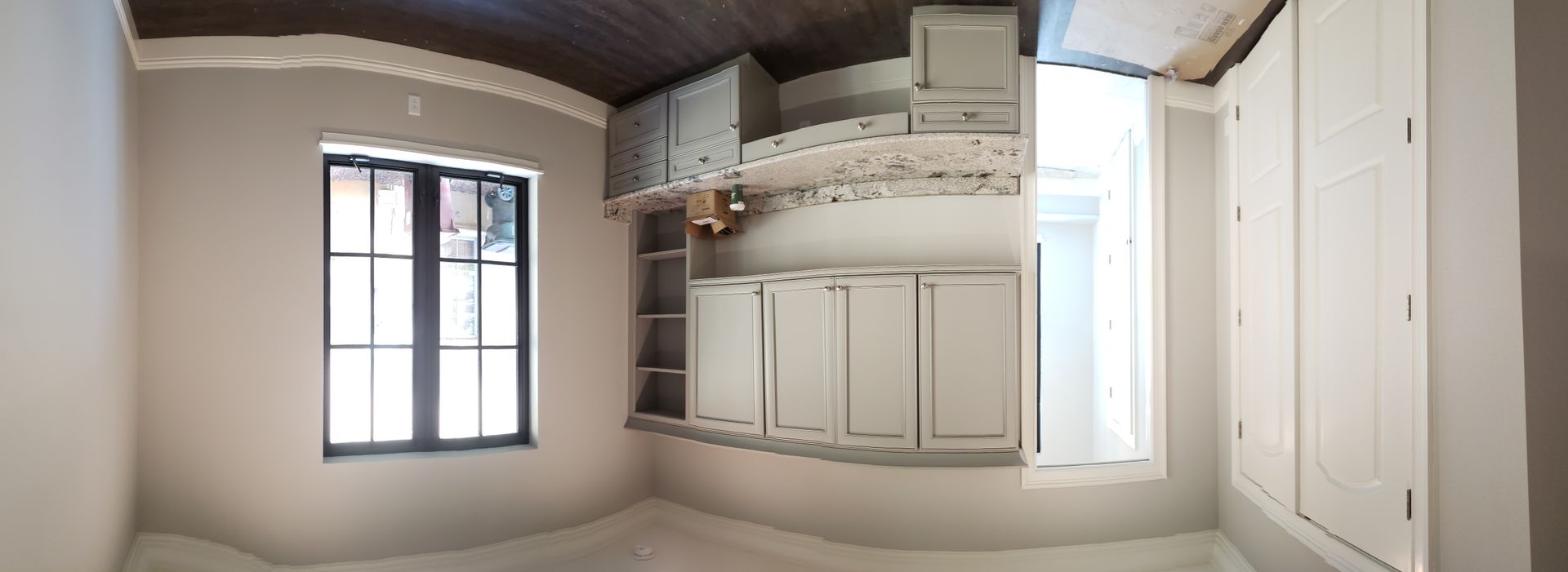 A room with white cabinets and a window in it