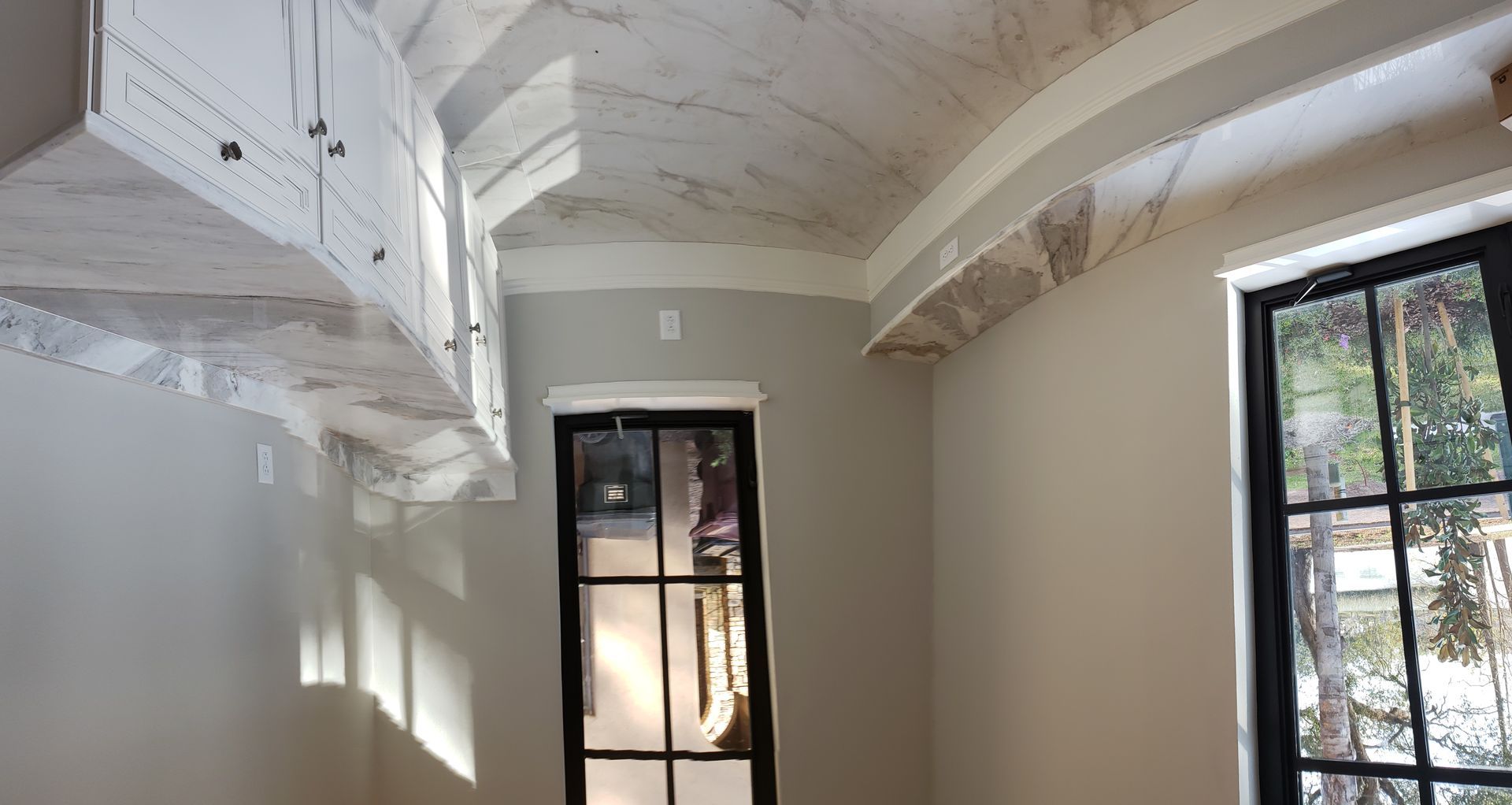 A room with a ceiling that is curved and a window.