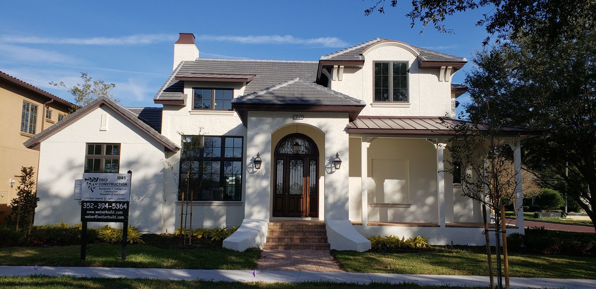A large white house with a for sale sign in front of it