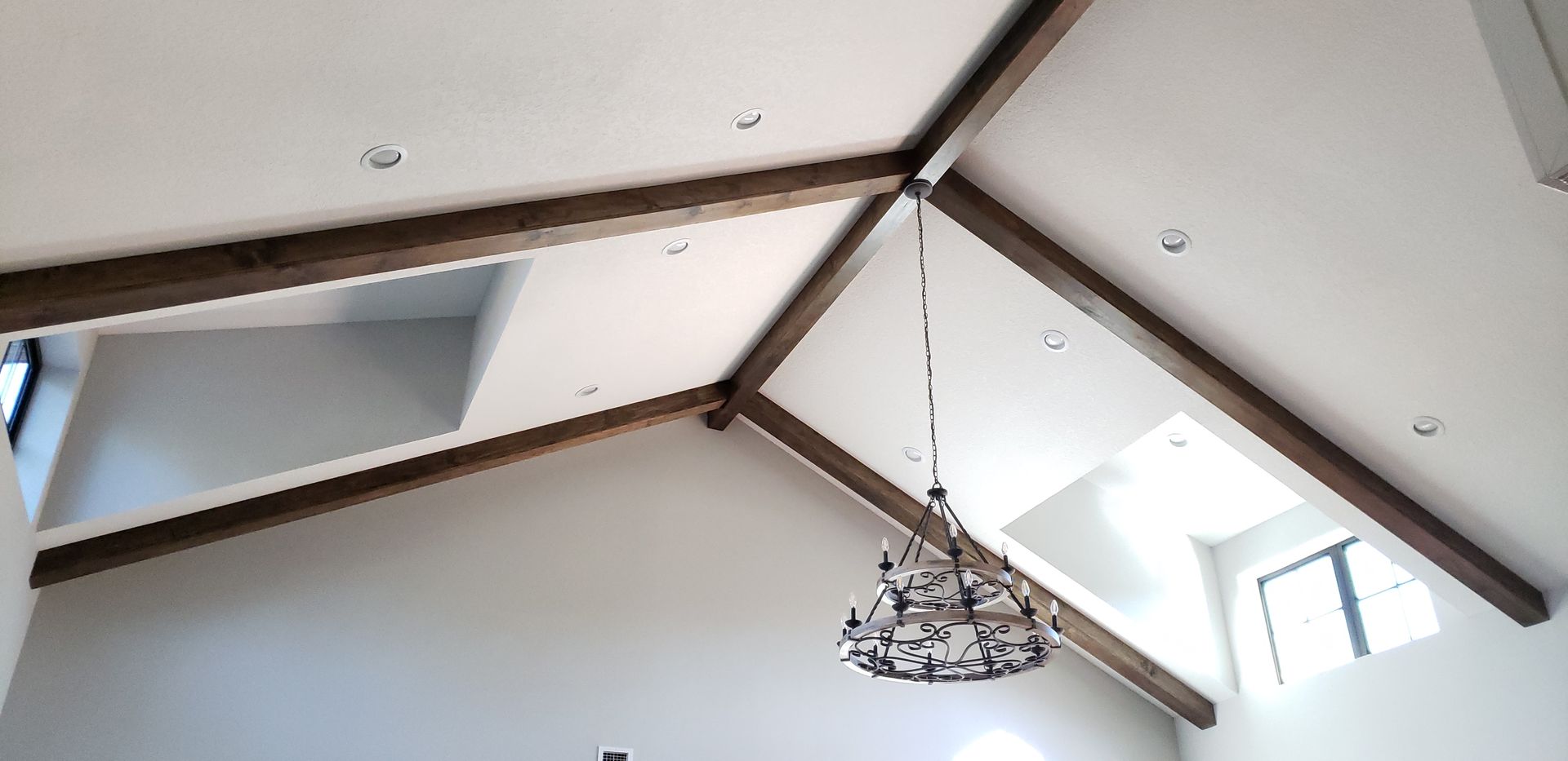 A chandelier is hanging from the ceiling of a room with a vaulted ceiling.