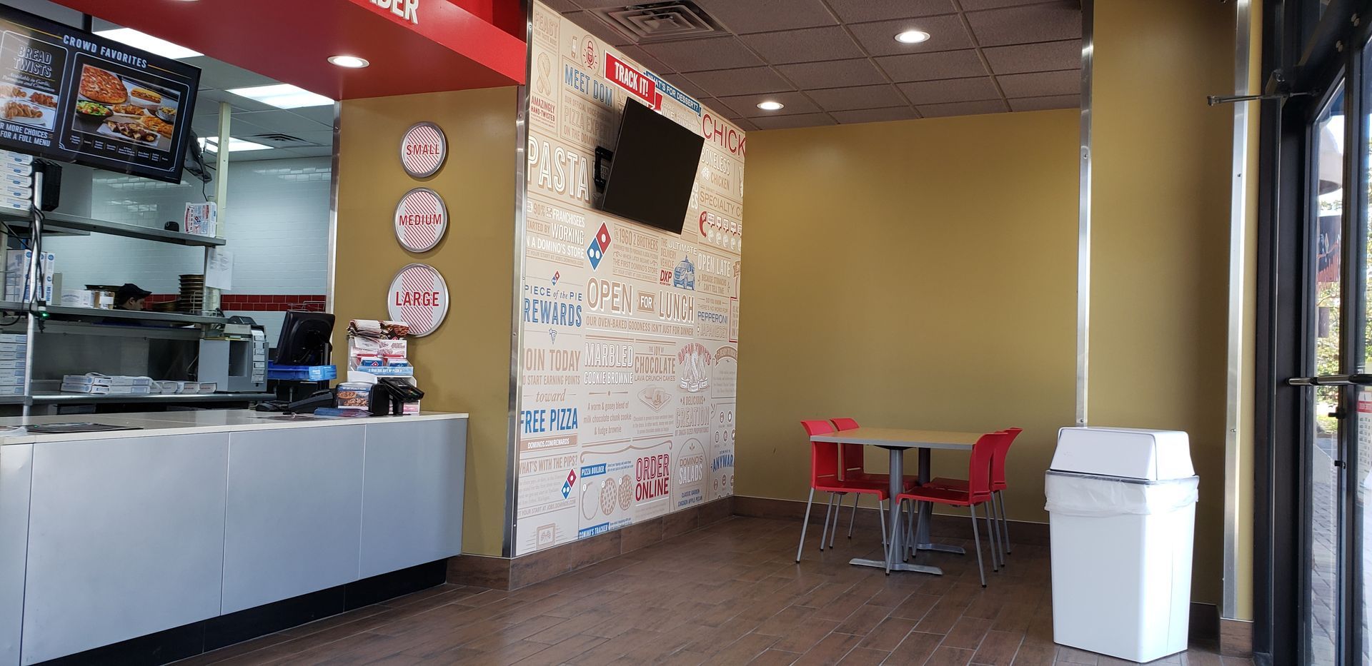 The inside of a domino 's pizza restaurant with tables and chairs.