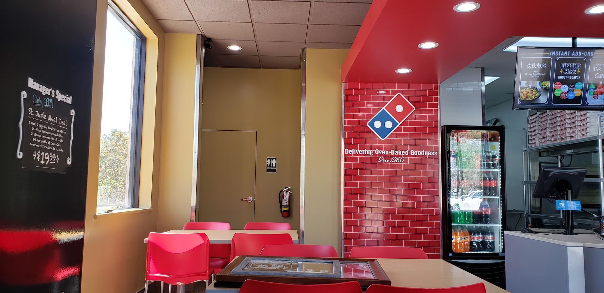 The inside of a domino 's pizza restaurant with tables and chairs.