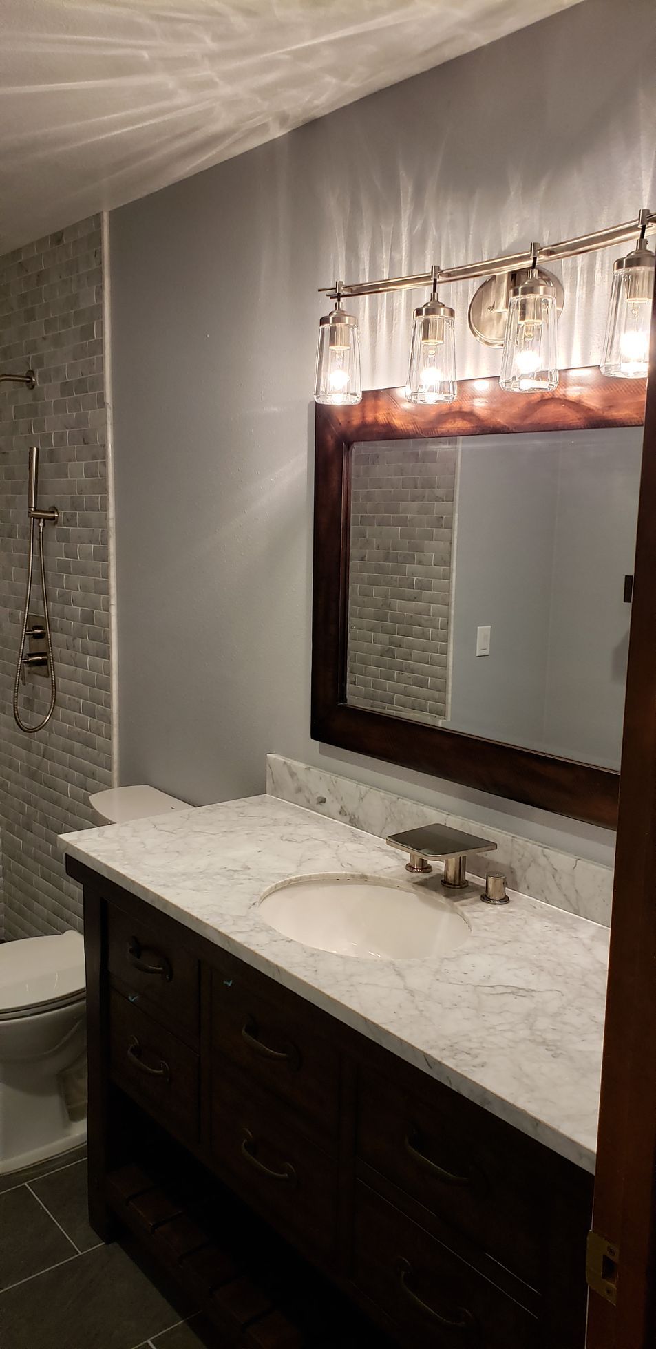 A bathroom with a sink , toilet and mirror.