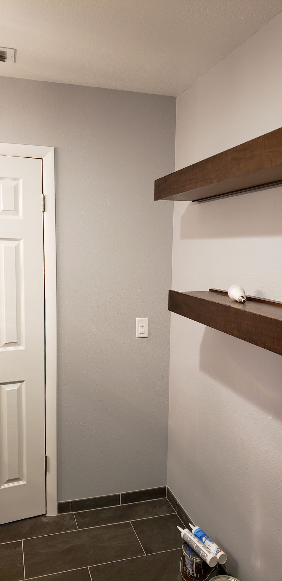 A room with a door and shelves in it.