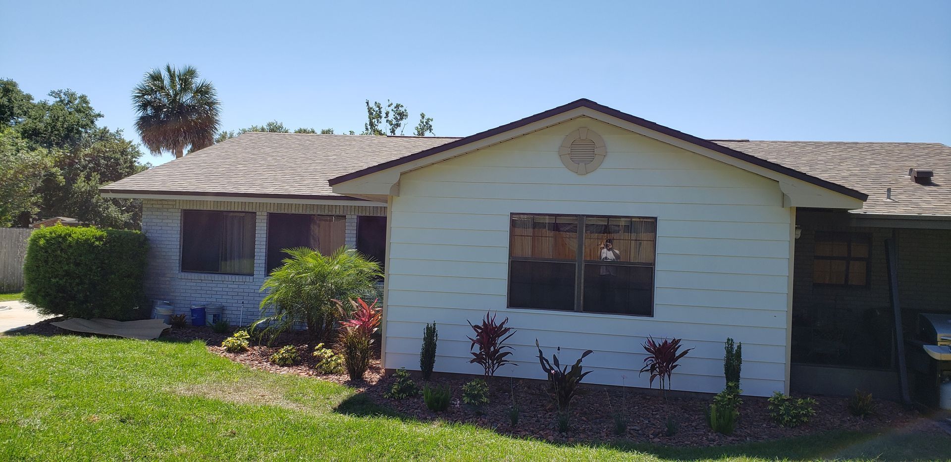 A white house with a roof that has shingles on it