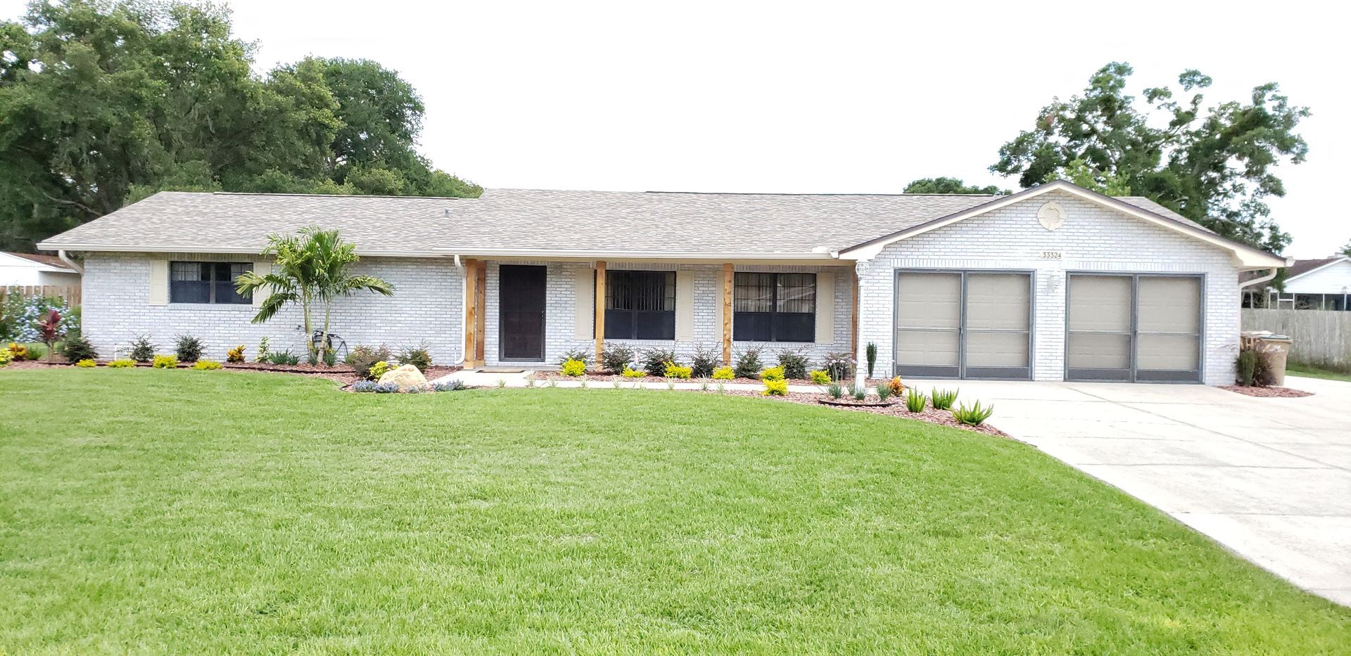 A white house with a large lawn in front of it.