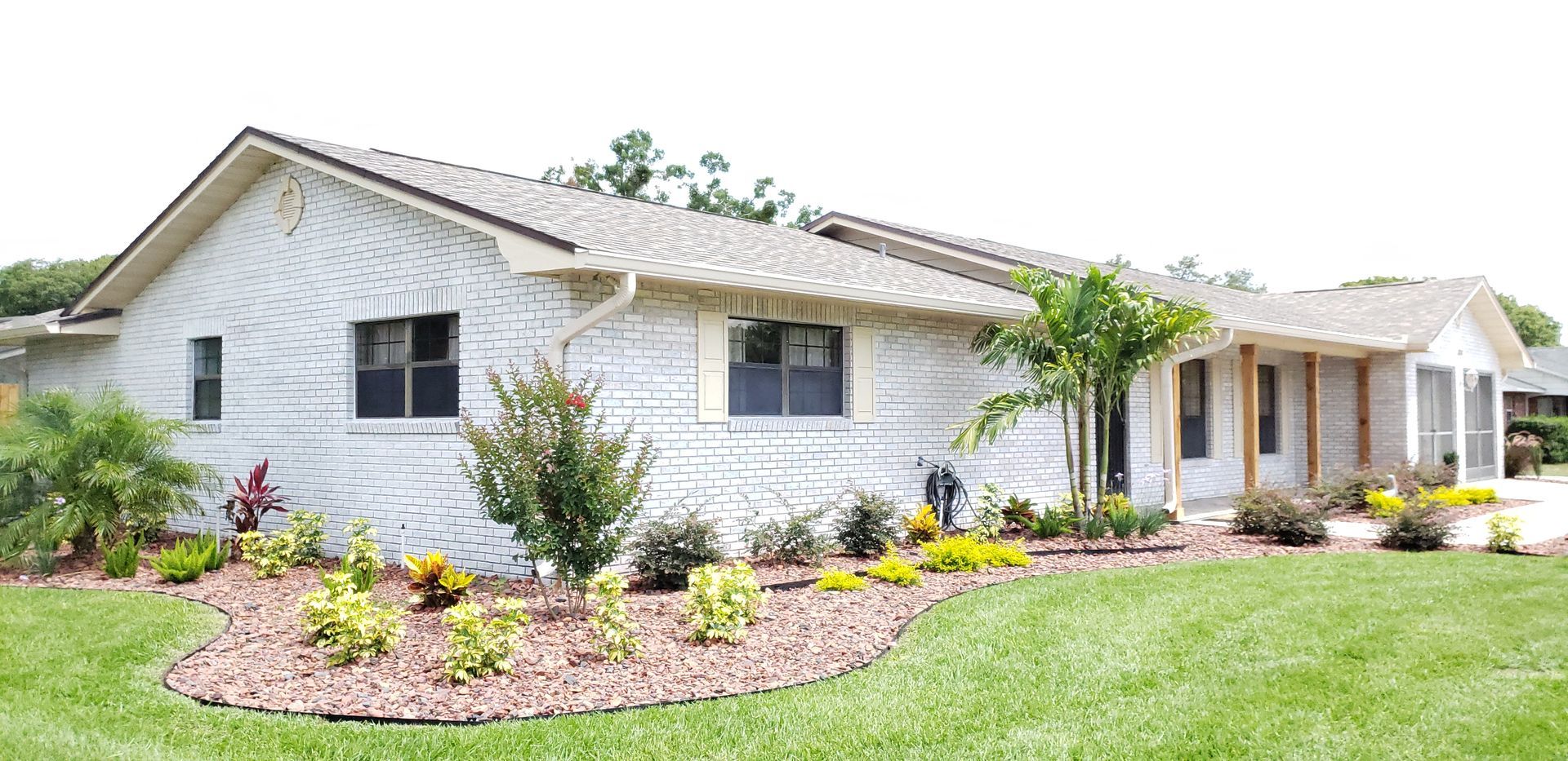 A white house with a lush green lawn in front of it