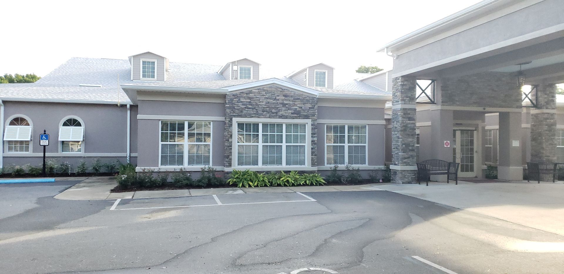 A large building with a lot of windows and a parking lot in front of it.