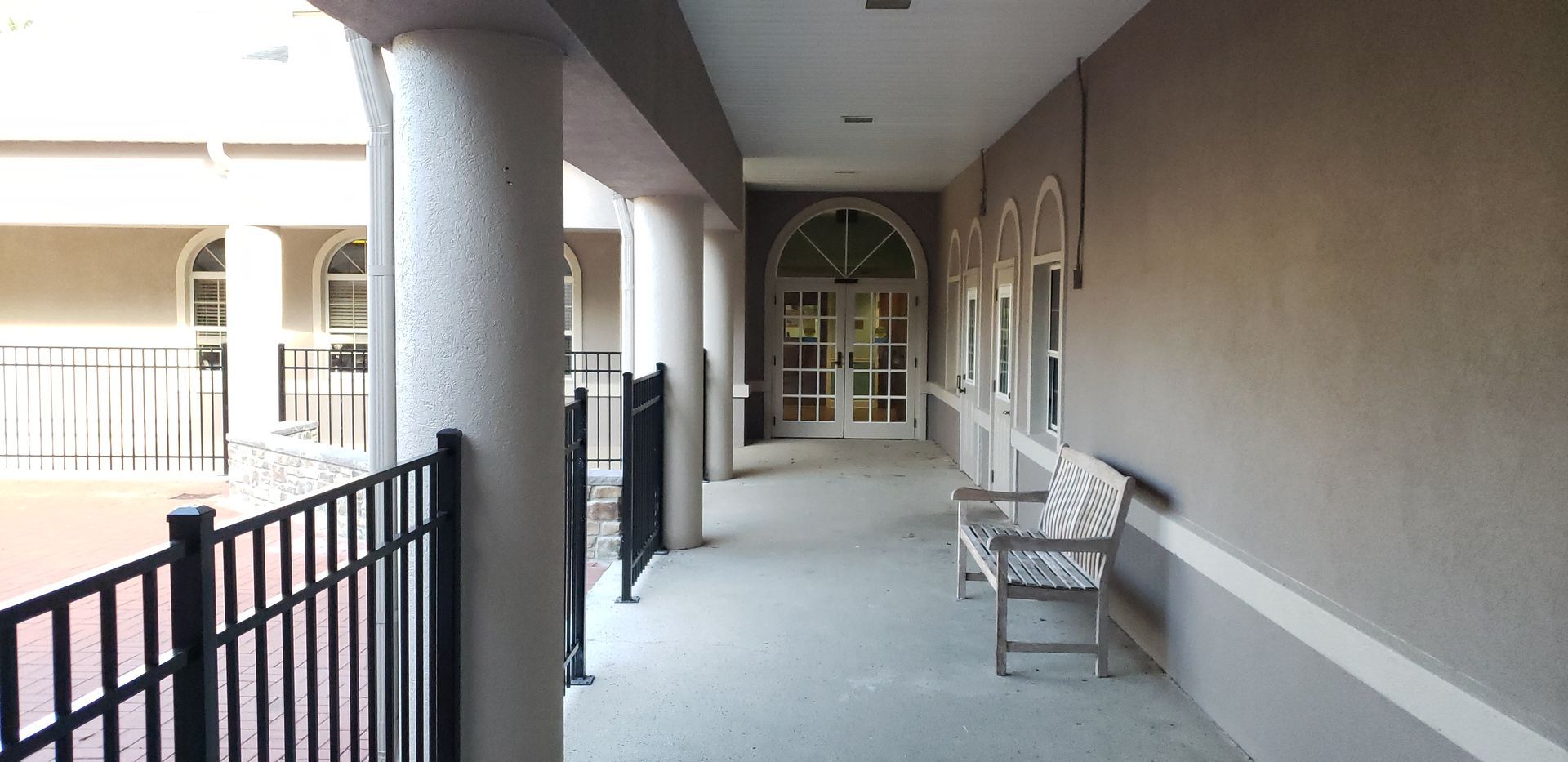 A long hallway with a bench in the middle of it