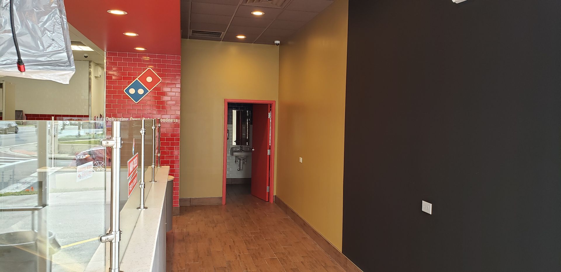 An empty domino 's pizza restaurant with a domino 's logo on the wall.