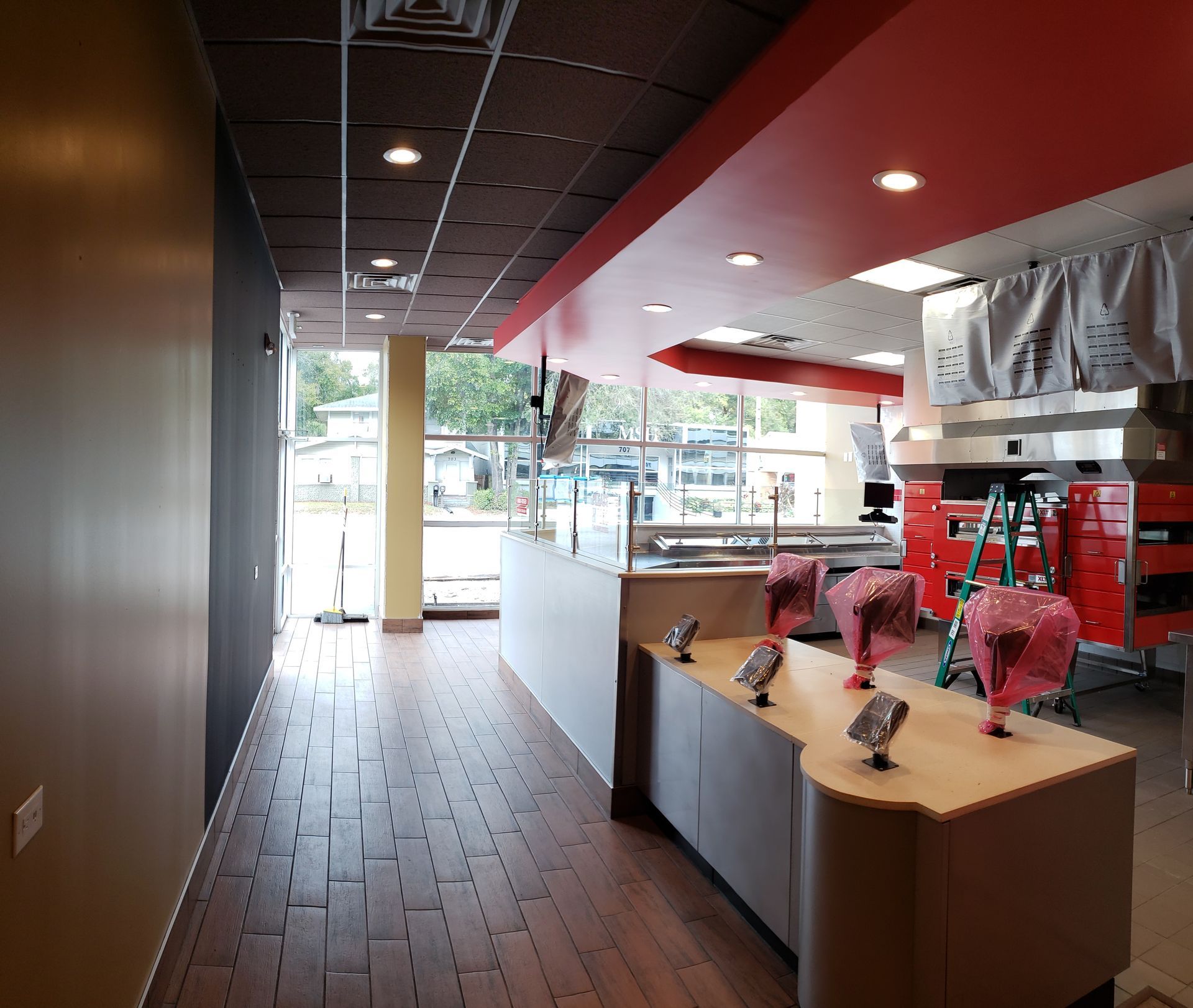 A long hallway in a restaurant with a red ceiling
