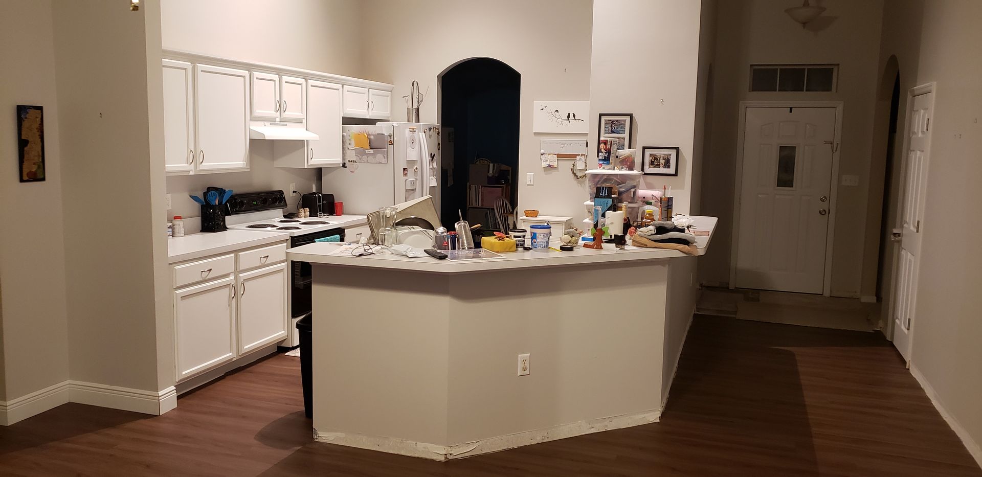 A kitchen with white cabinets and a large island in the middle of the room.