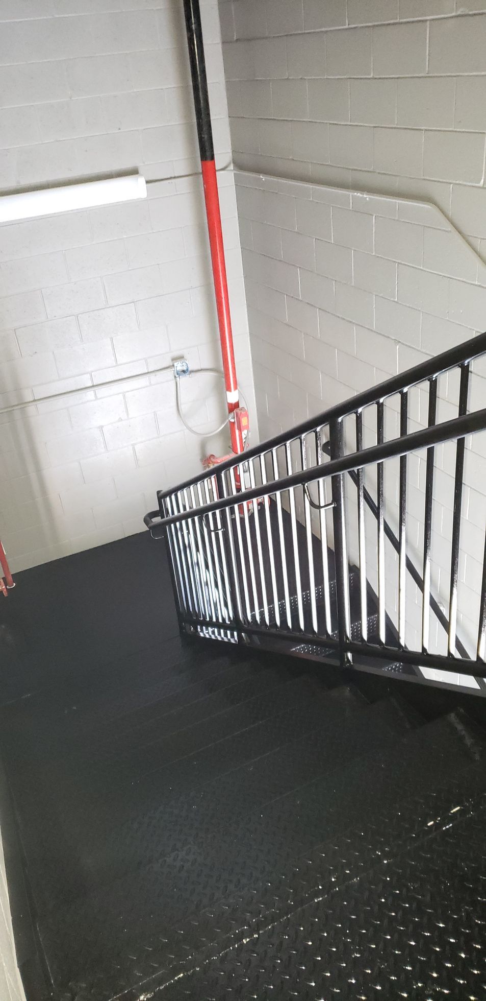 A black staircase with a metal railing in a building.