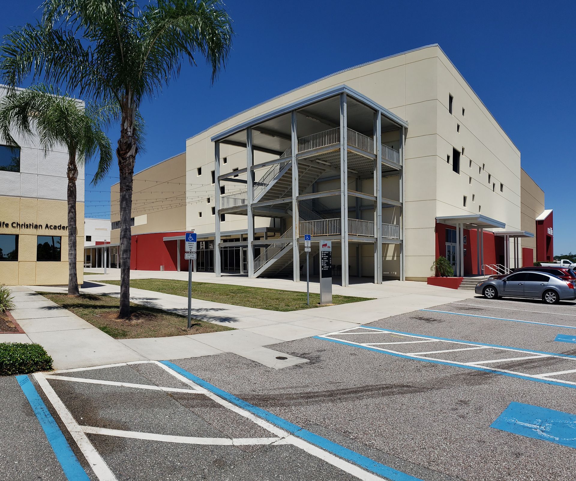A car is parked in a handicapped parking spot in front of a building