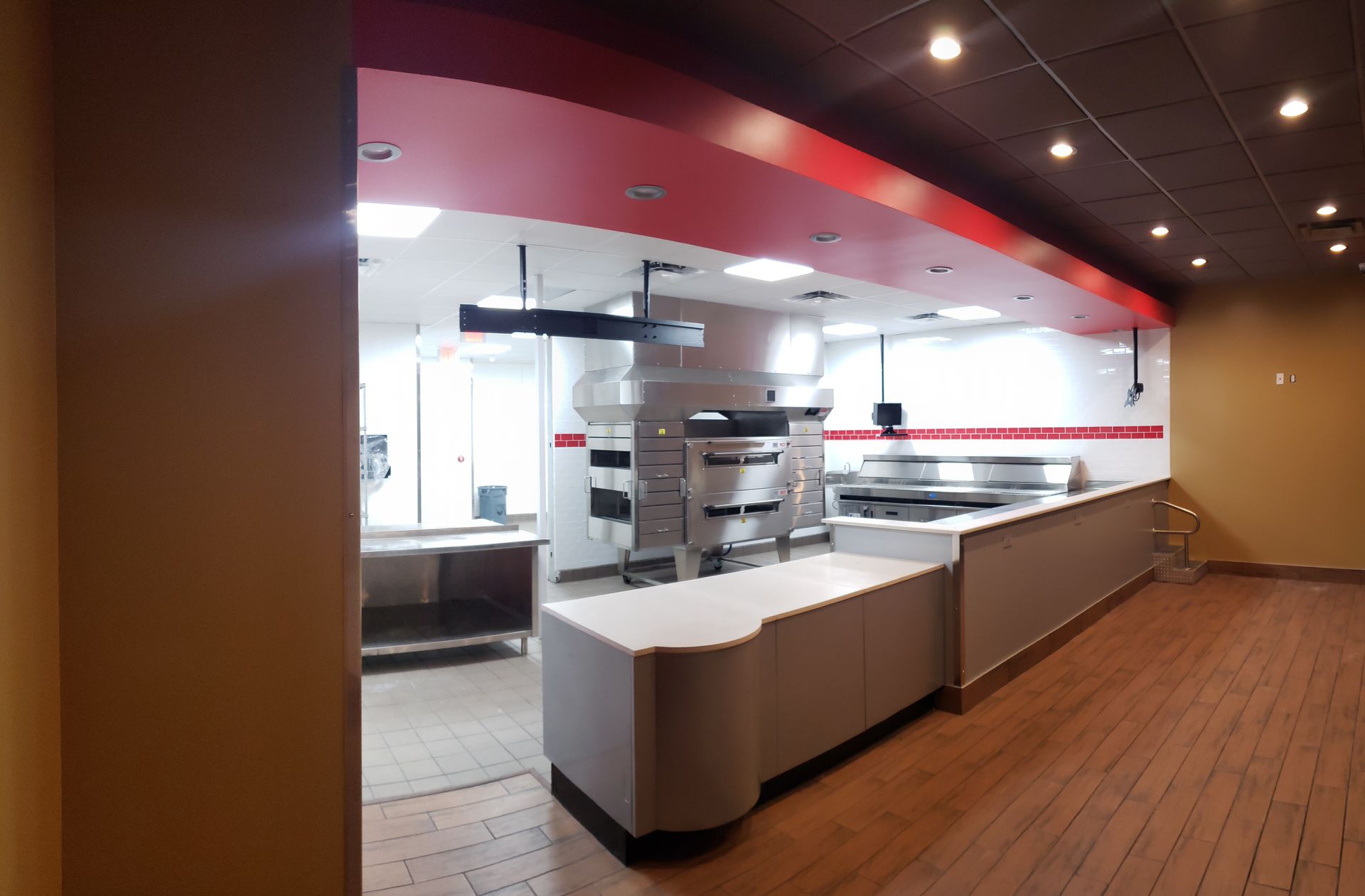 An empty restaurant with a red ceiling and a white counter