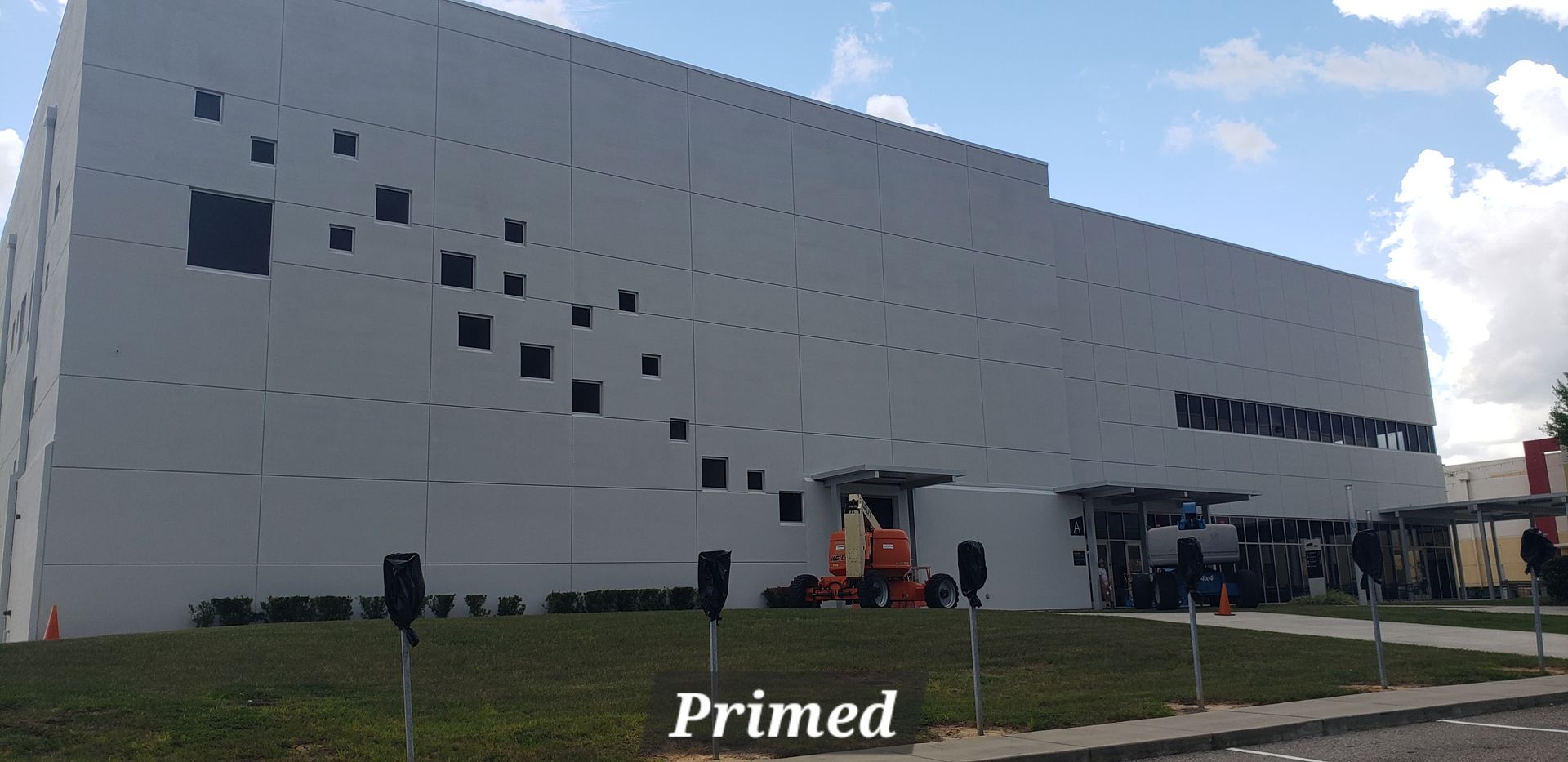 A large white building with black squares on the side of it.