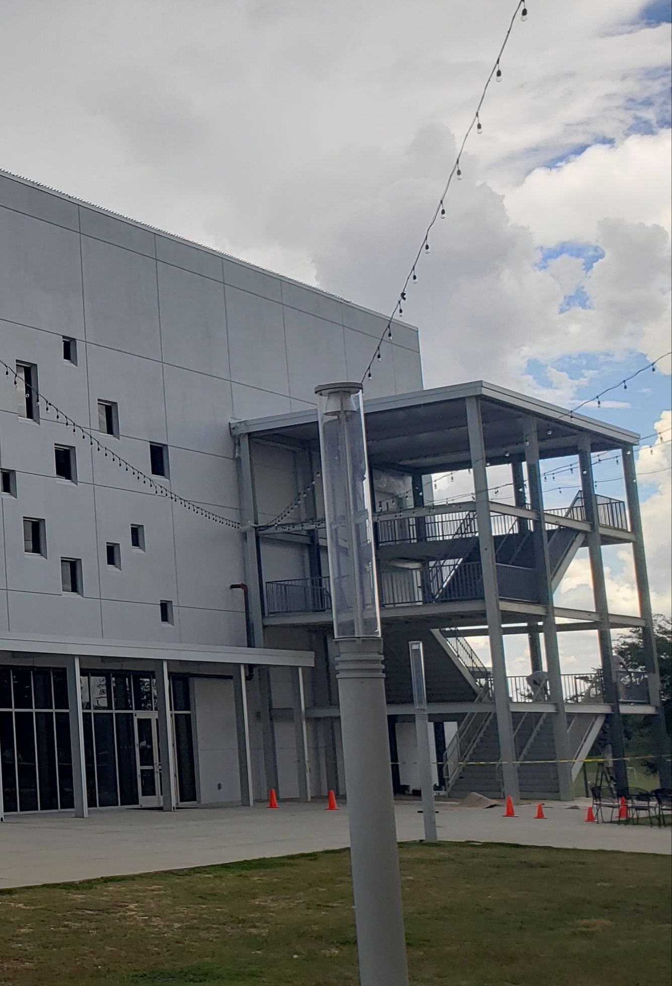 A large white building with stairs leading up to it is under construction.