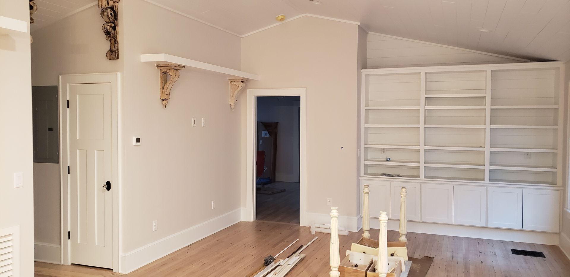 A living room with a lot of shelves and candles on the floor.