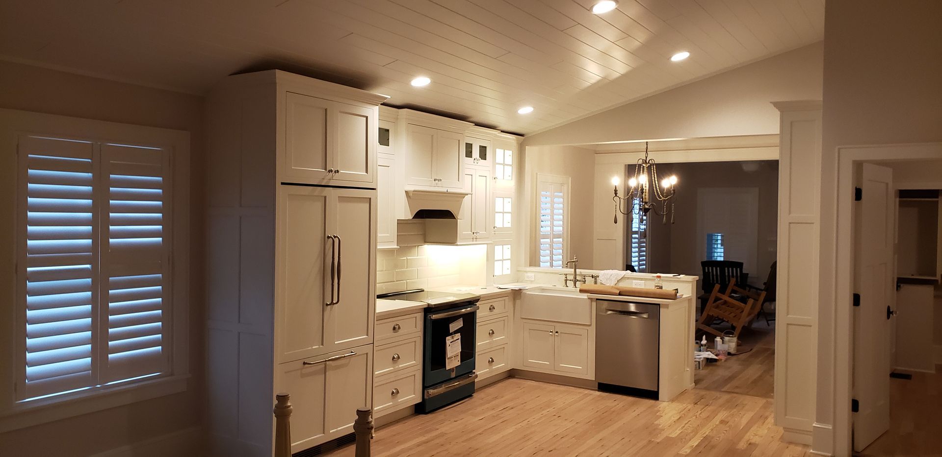 A kitchen with white cabinets , stainless steel appliances , and hardwood floors.