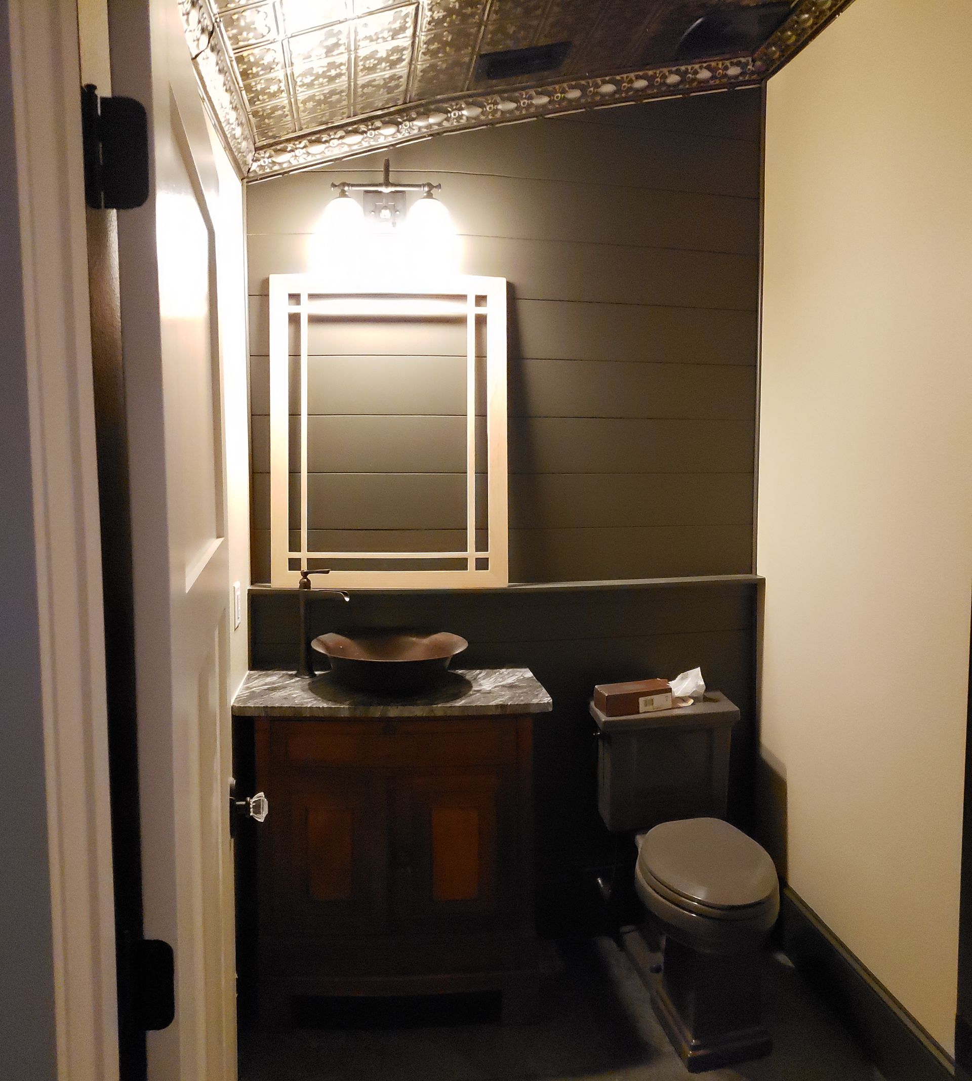 A bathroom with a toilet a sink and a mirror