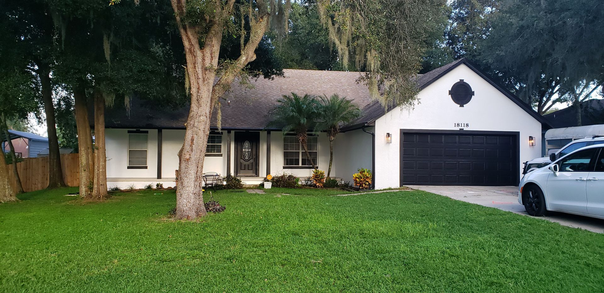 A white house with a car parked in front of it.