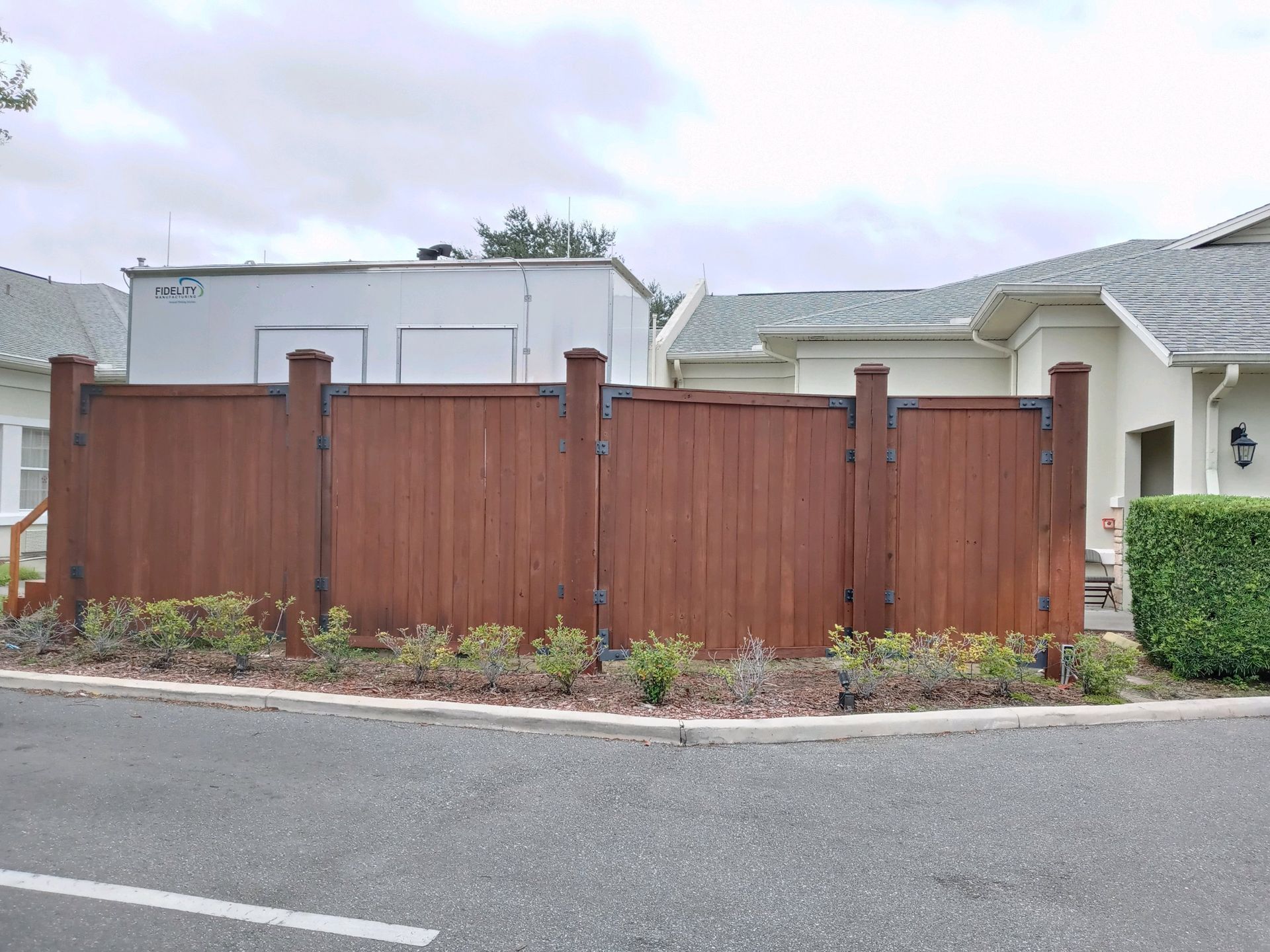 A wooden fence with a gate in front of a house