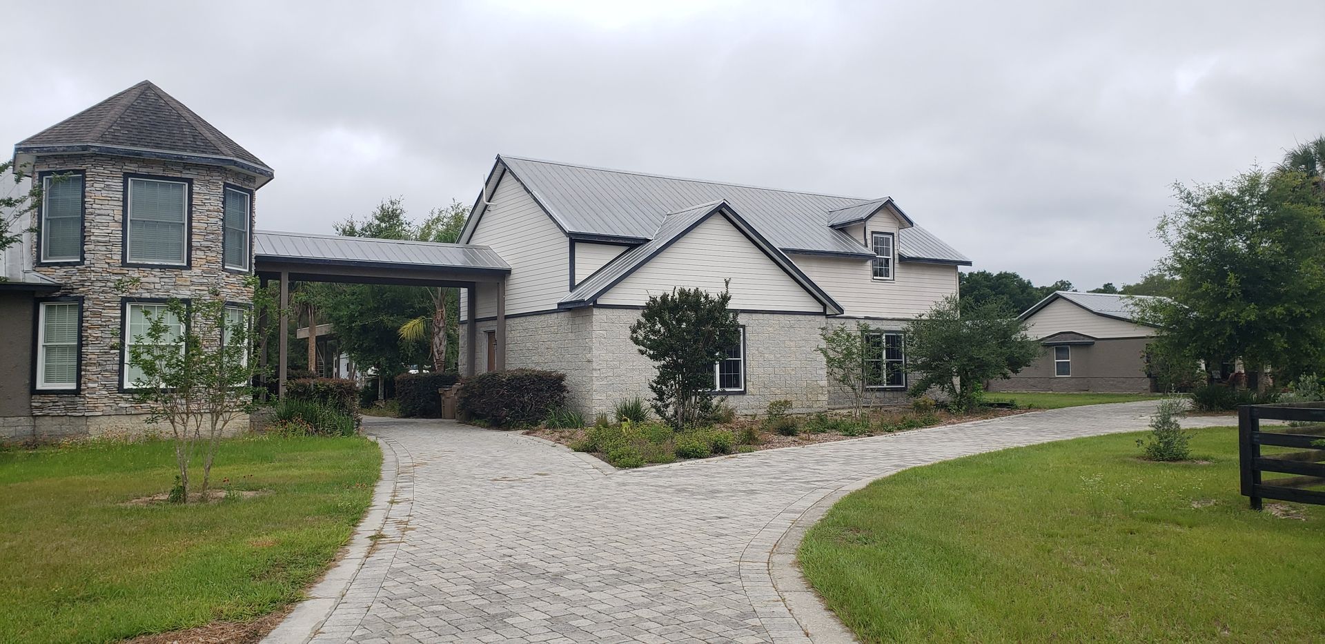 A large house with a cobblestone driveway leading to it.