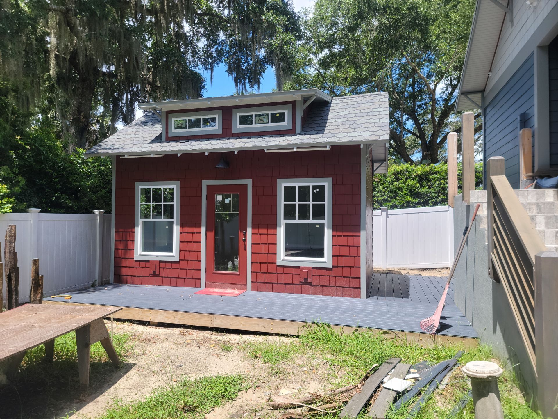 A small red house is being built in a backyard