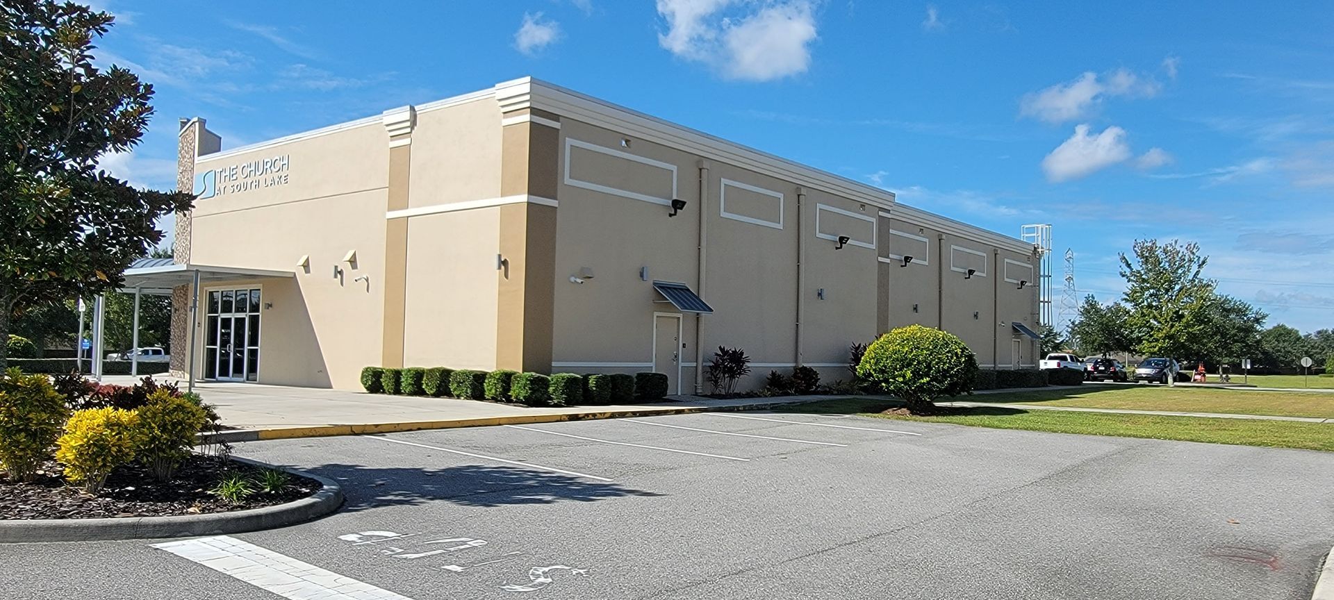 A large building with a lot of windows is sitting in a parking lot.