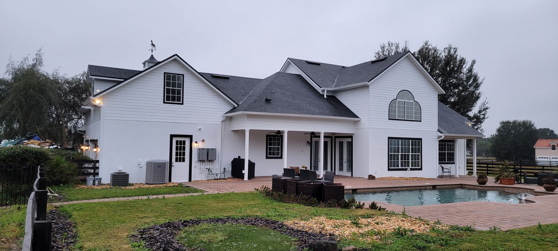 A large white house with a swimming pool in the backyard.