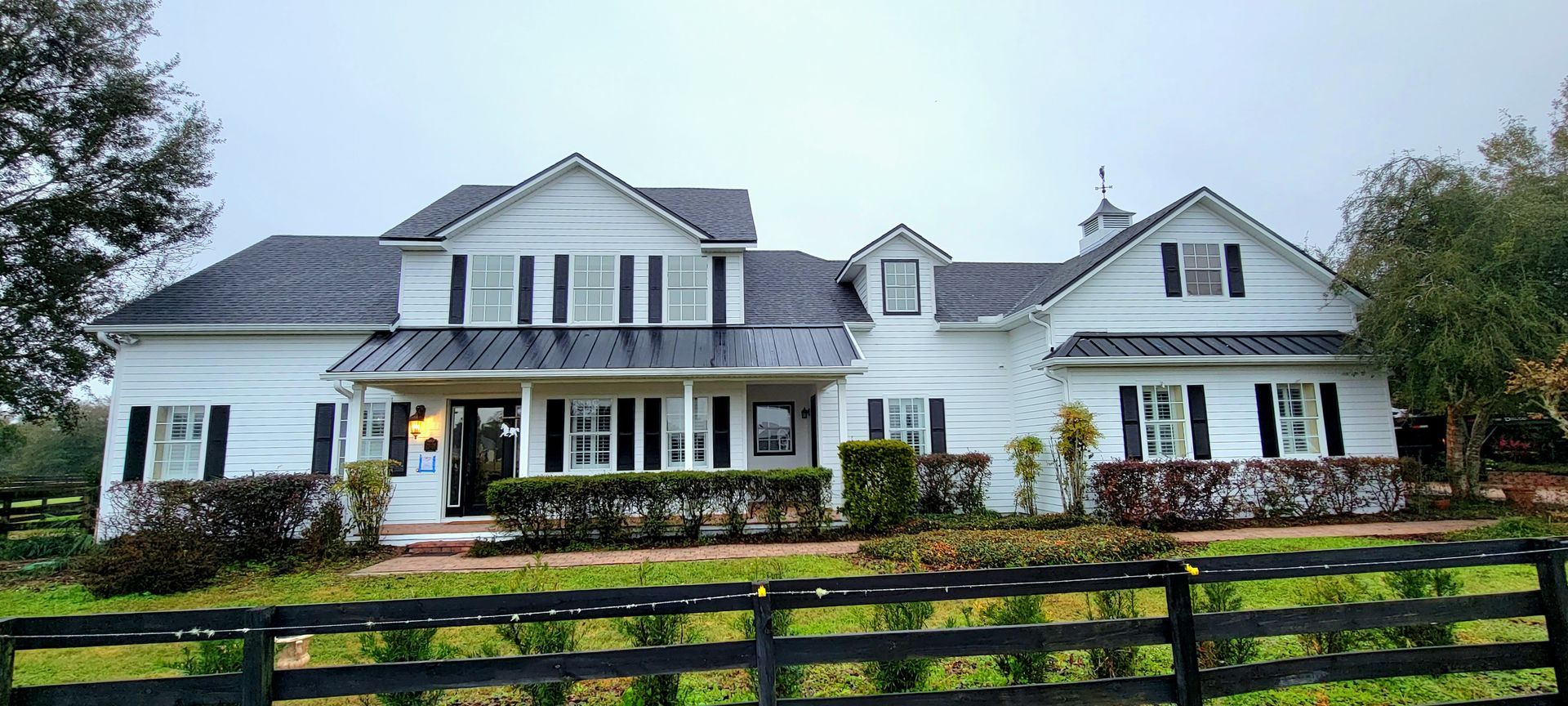A large white house with a black fence in front of it