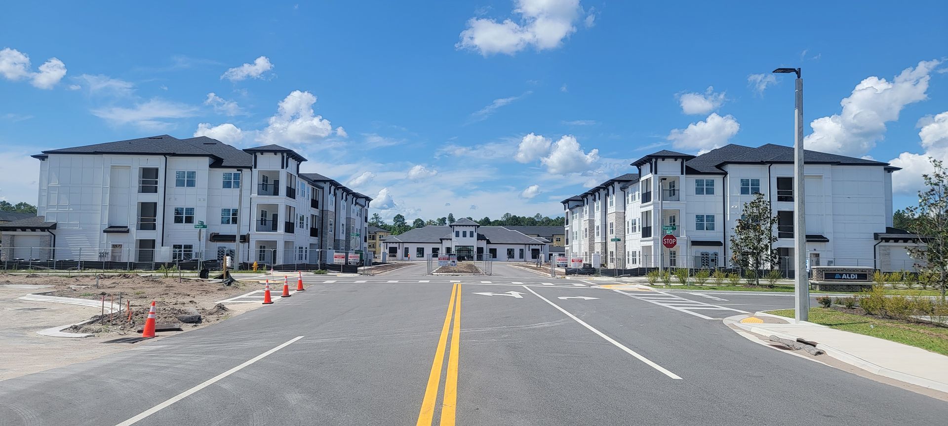 A row of apartment buildings are being built on the side of a road.