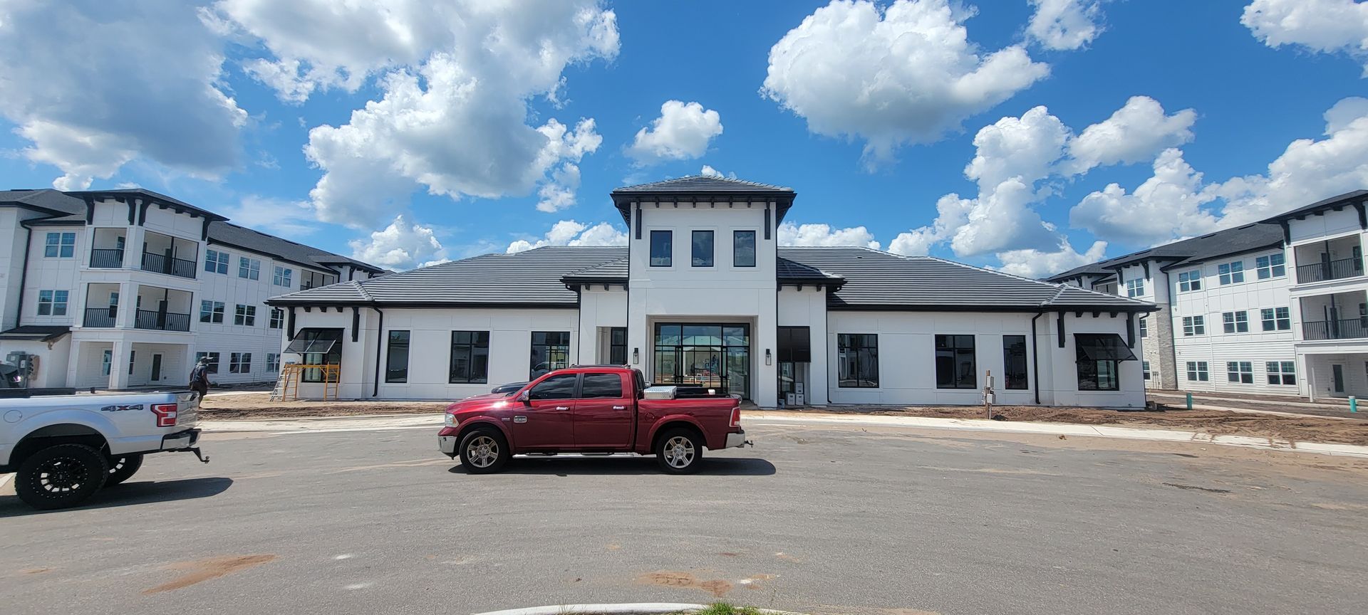 A red truck is parked in front of a building under construction.