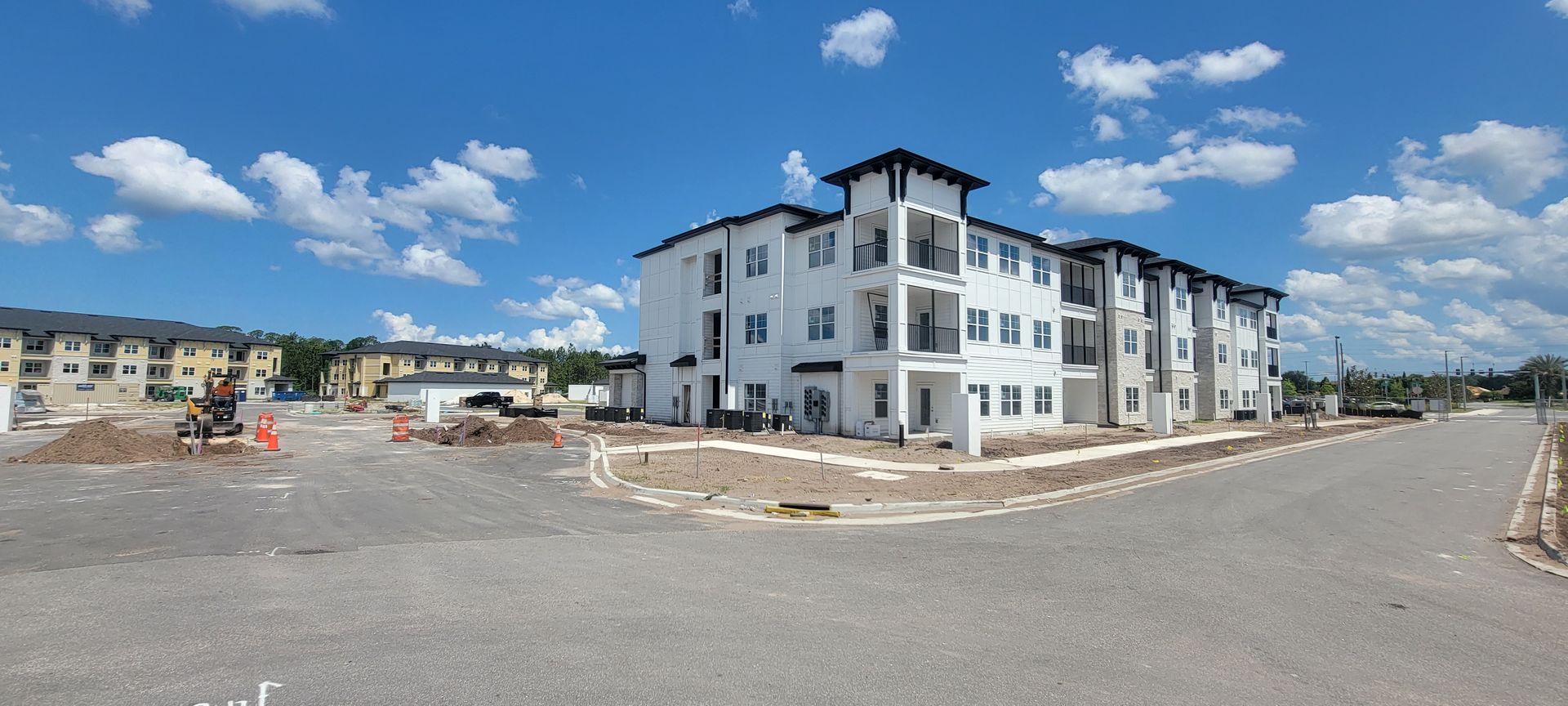 A large apartment building is being built on a sunny day.