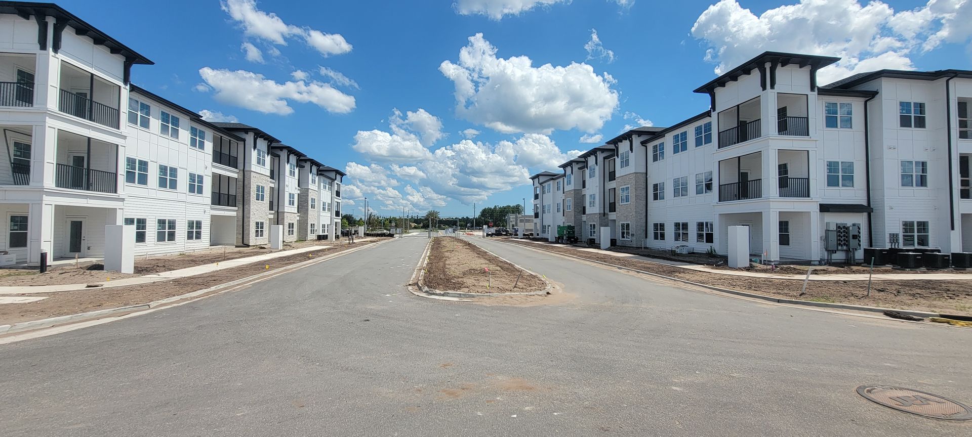 A row of apartment buildings are lined up on the side of a road.