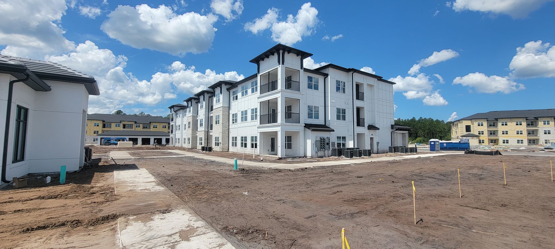 A large apartment building under construction with a lot of dirt in front of it.