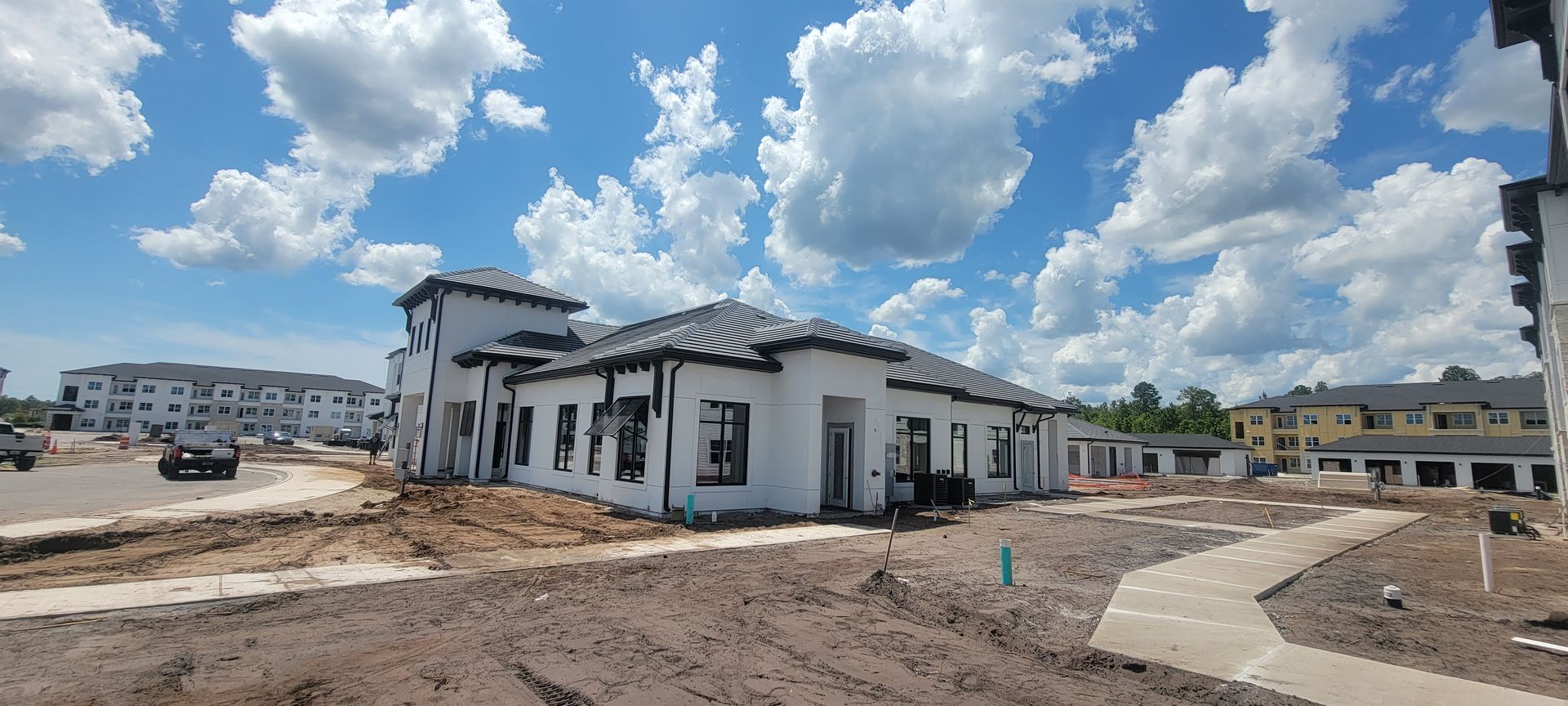 A large white building is being built in a residential area.