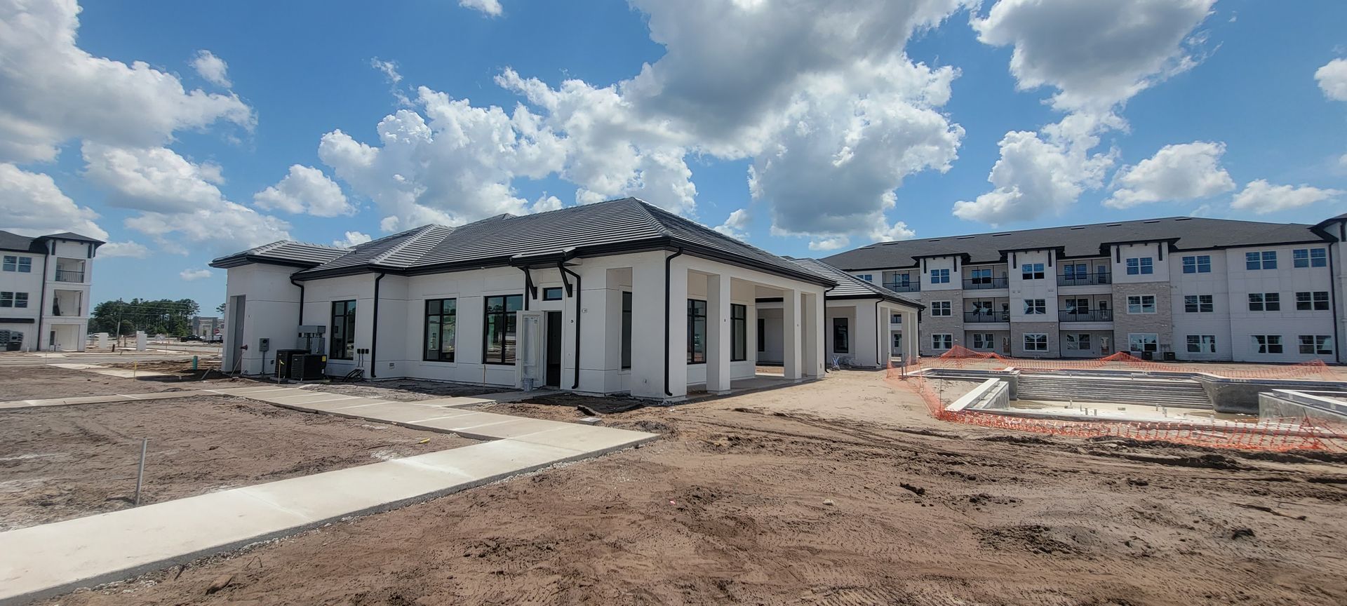 A large building is being built in the middle of a dirt field.