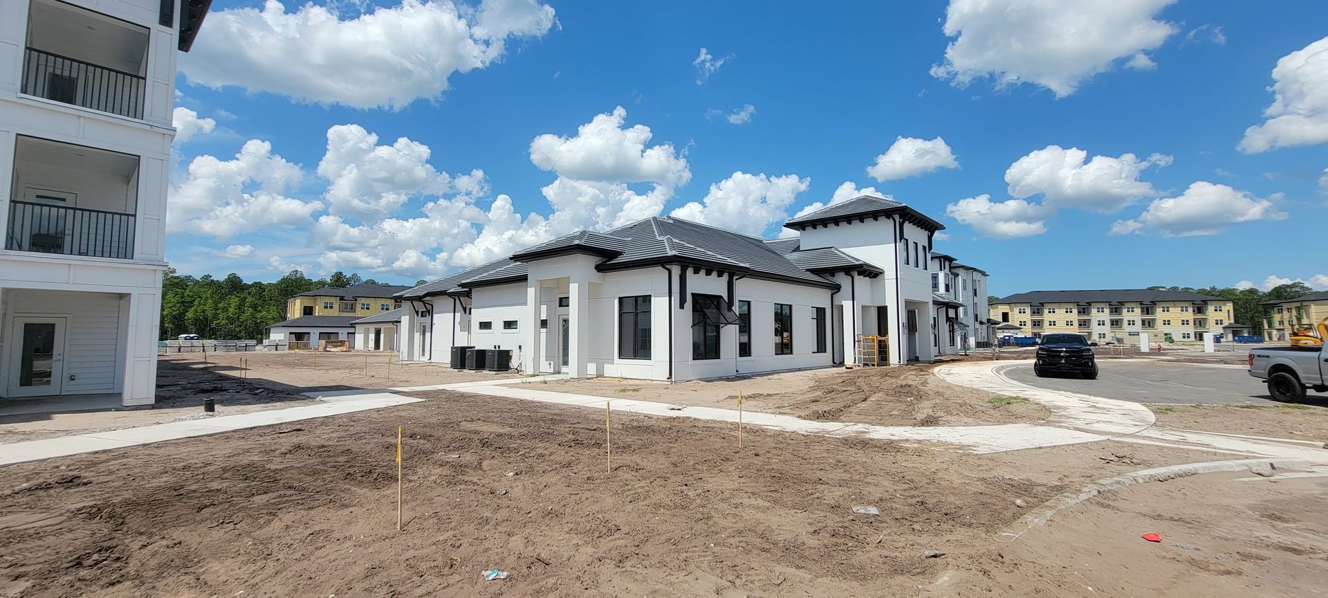 A group of buildings are being built in a dirt field.