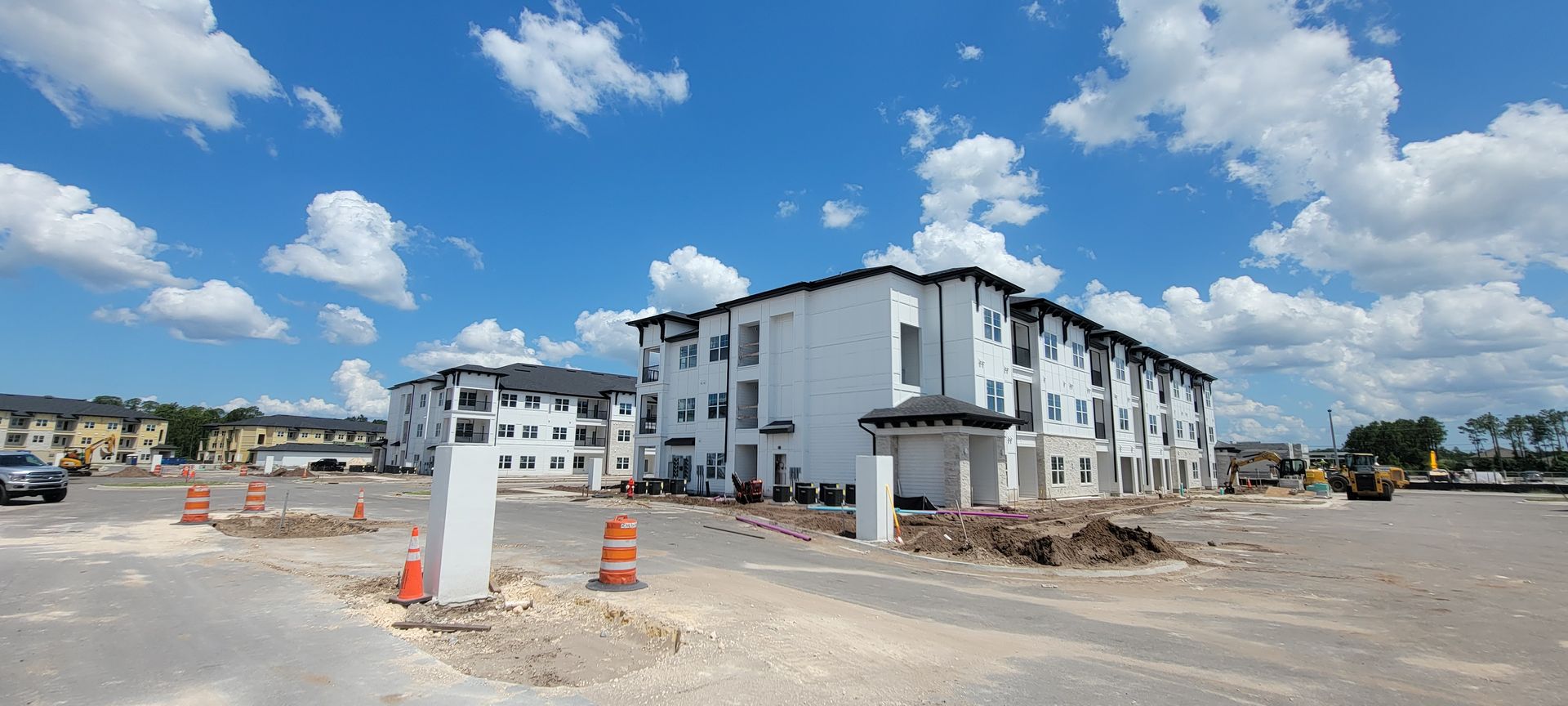 A large apartment building is being built in a parking lot.