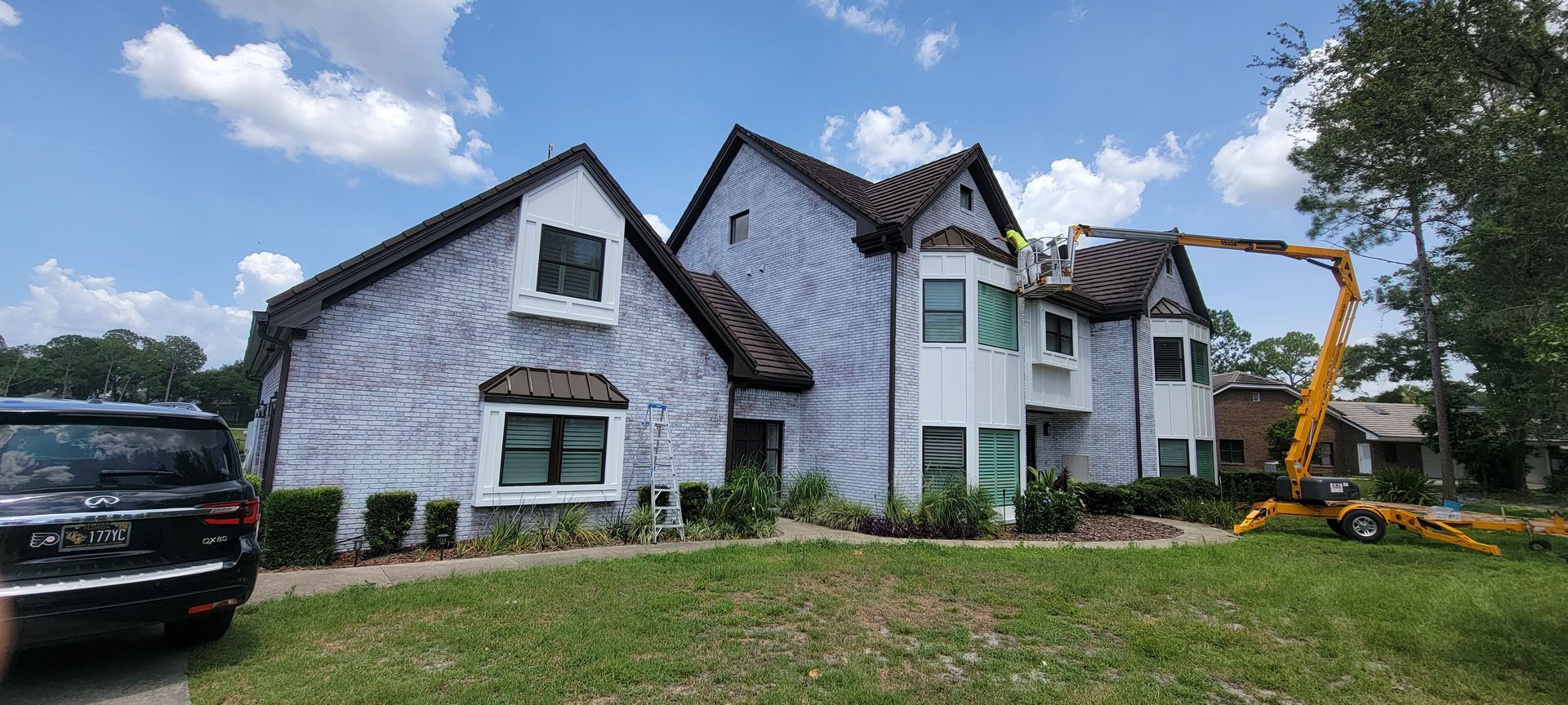 A large white house with a yellow crane in front of it.