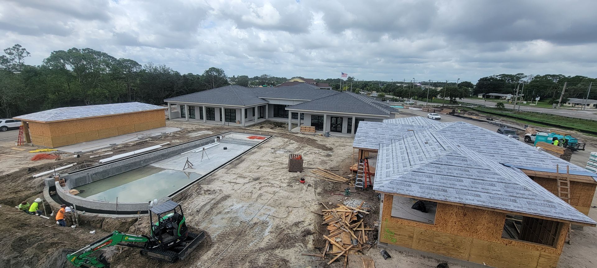 An aerial view of a house under construction with a pool.