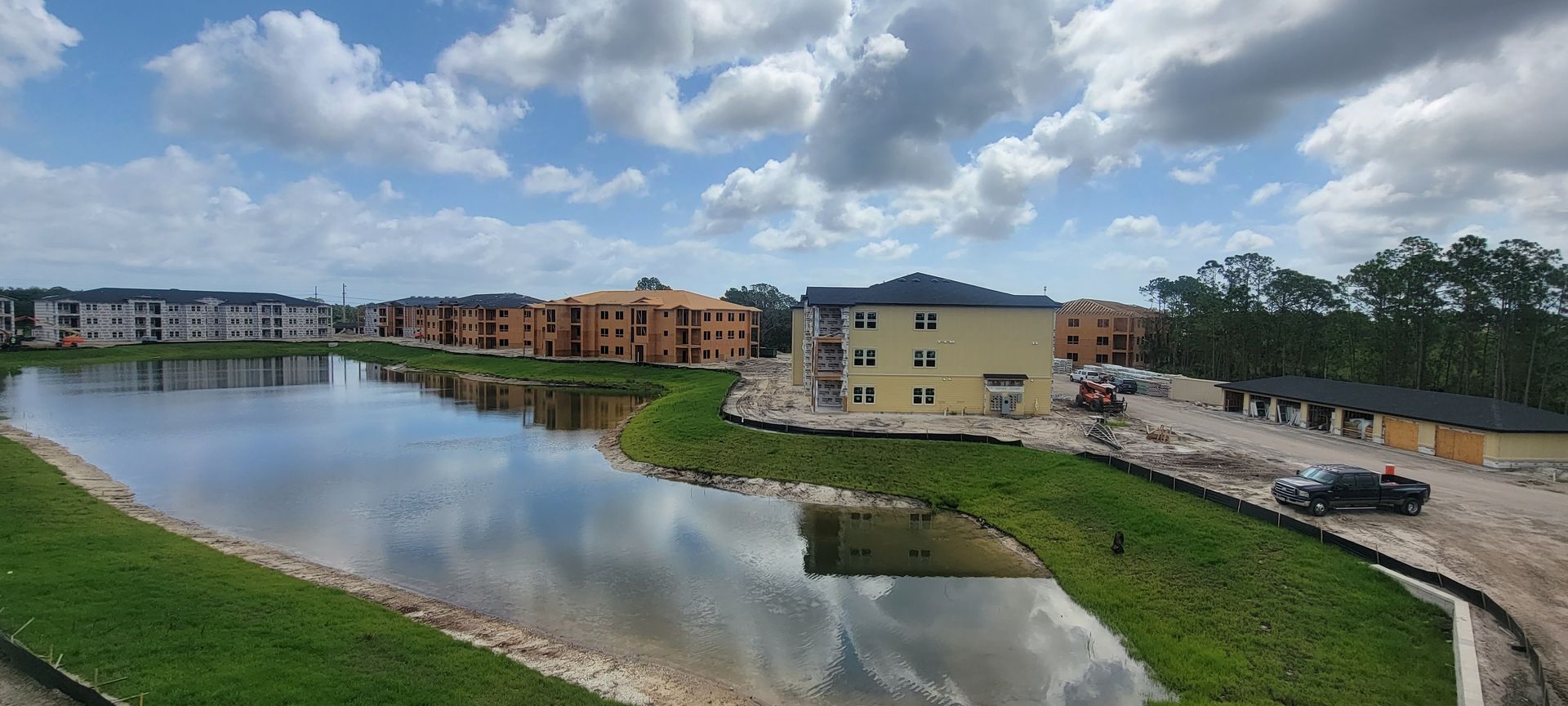 An aerial view of a building under construction next to a lake.