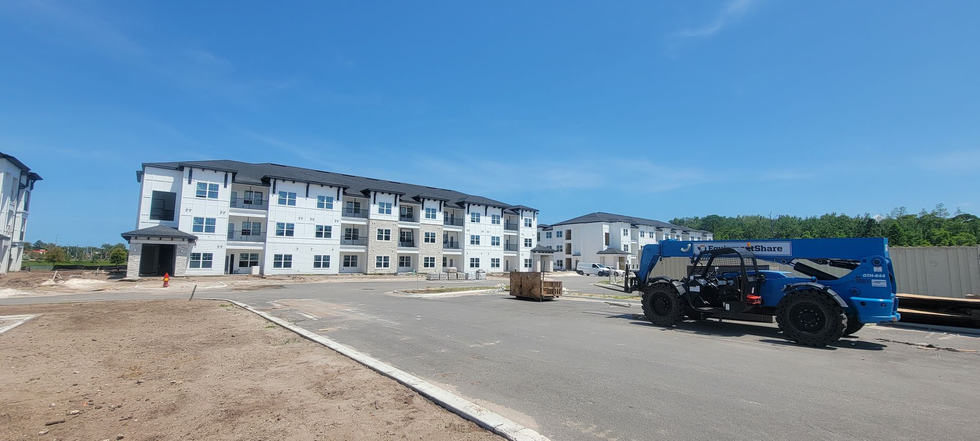 A tractor is parked in front of a building under construction.