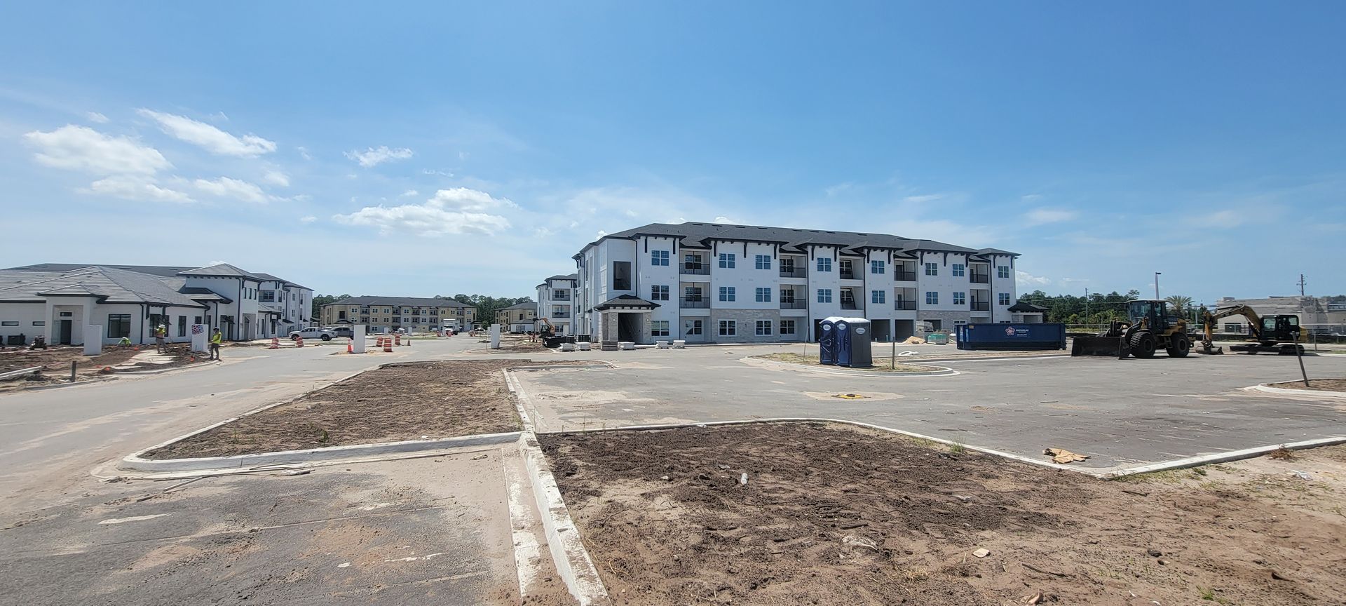 A large building is being built in the middle of a dirt field.