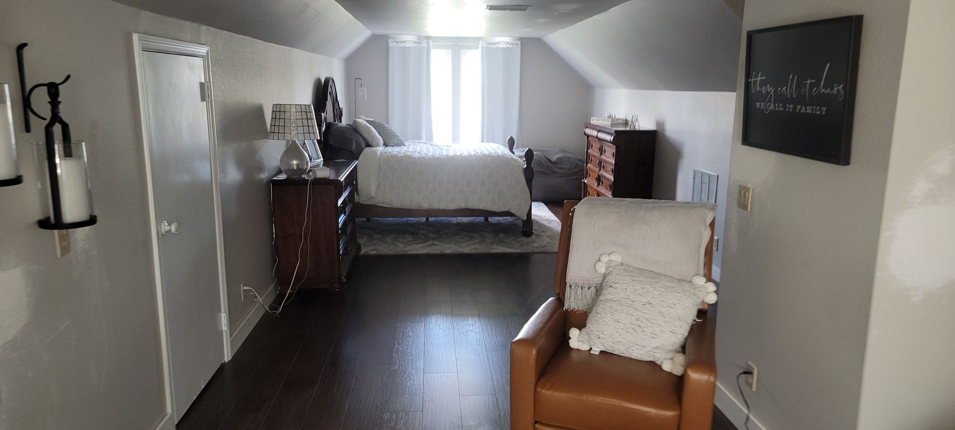 A bedroom with a bed , dresser , chair and television.