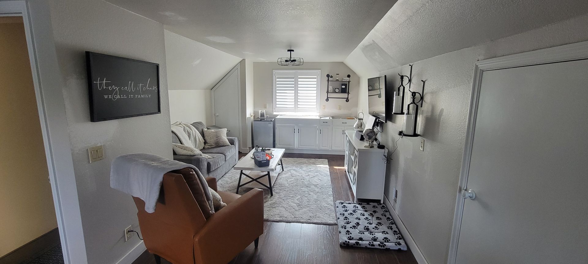 A living room with a couch , chair , coffee table and television.
